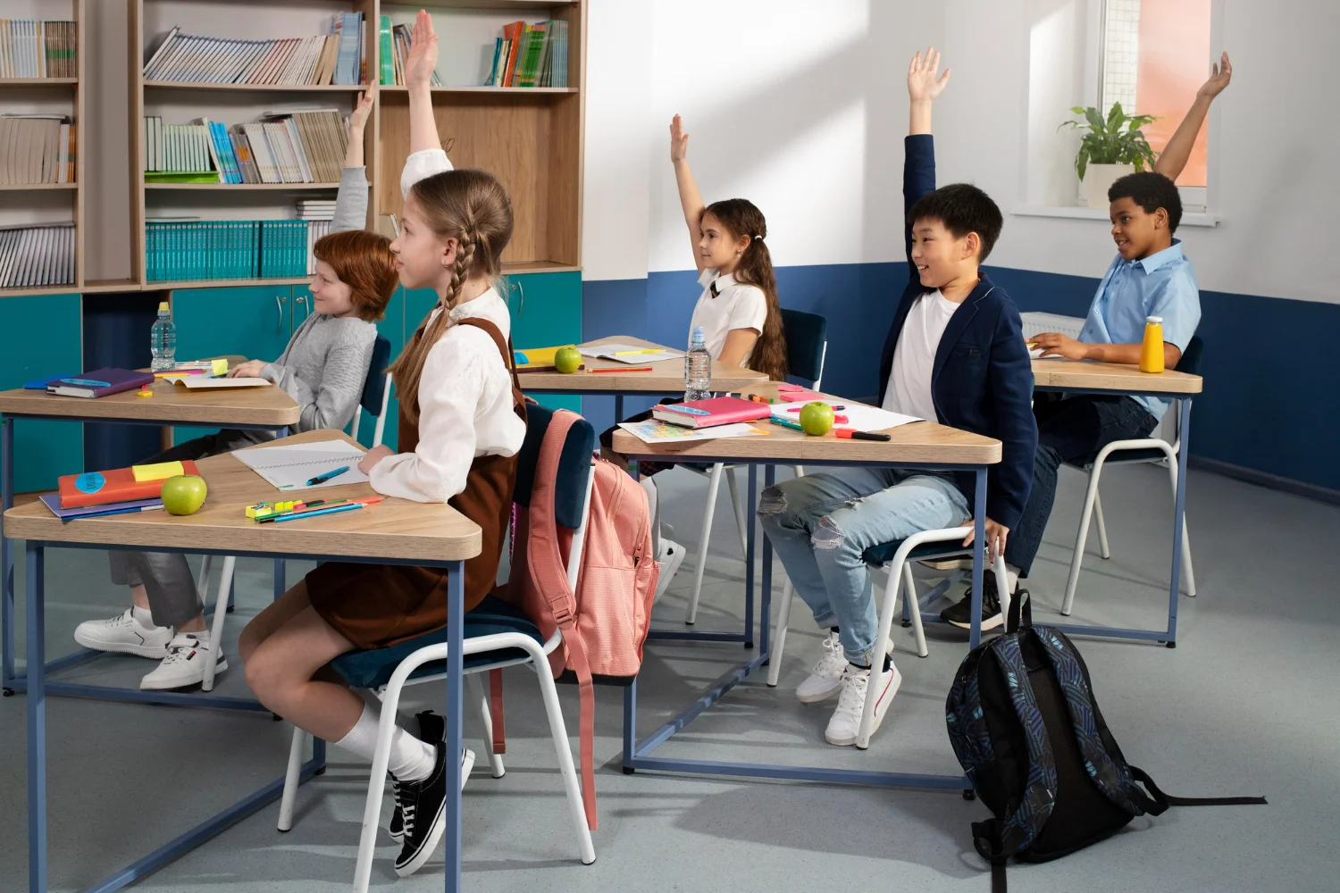 Niños en el aula levantando la mano